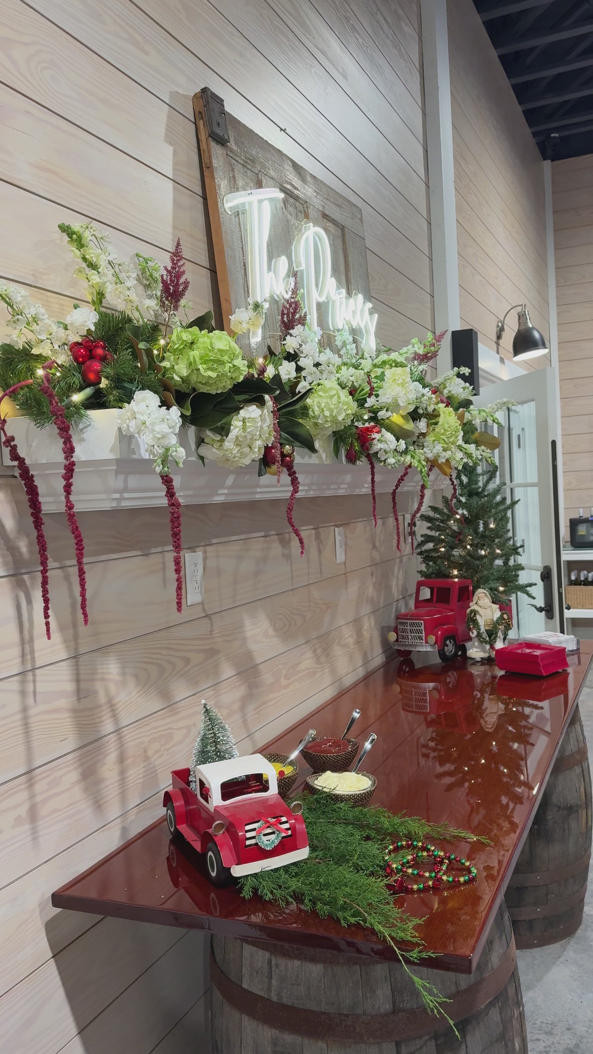 A mantle decorated with red, white, and green Christmas flowers.