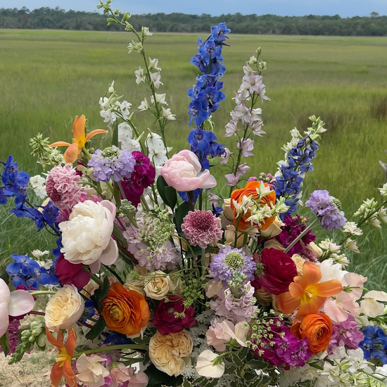 An extra large flower arrangement with pink, blue, orange, and white flowers. 