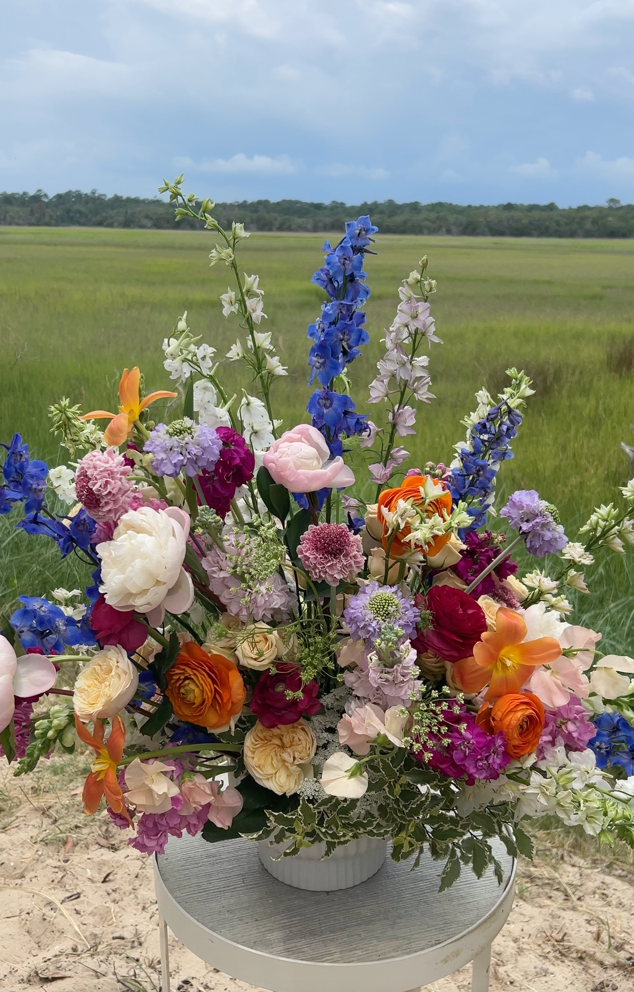 An extra large flower arrangement with pink, blue, orange, and white flowers. 
