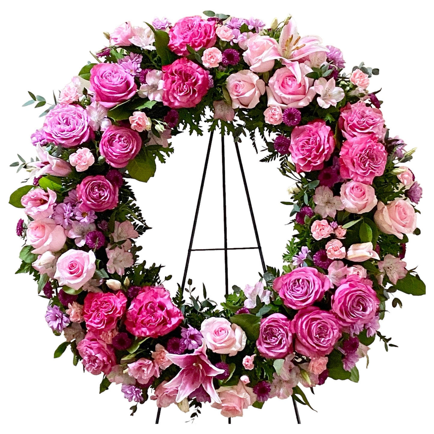 A floral wreath made of a variety of pink flowers for a standing funeral spray.